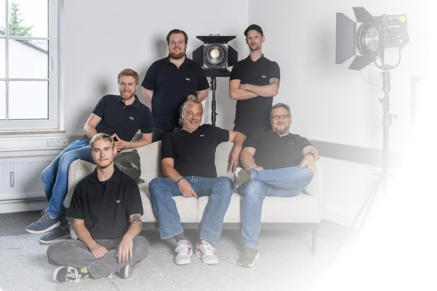 Technikerteam für Veranstaltungstechnik Nürnberg: Crew in Arbeitskleidung vor schwarzem Hintergrund